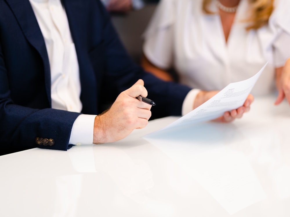 An advisor and a business owner reviewing a financial statement together at a meeting table